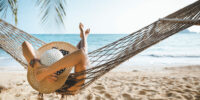 Summer travel vacation concept, Happy traveler asian woman with white bikini relax in hammock on beach in Koh mak, Thailand